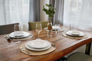 a wooden table with plates and wine glasses on it at Ferienwohnung Merlin in Ettenheim +15 photos