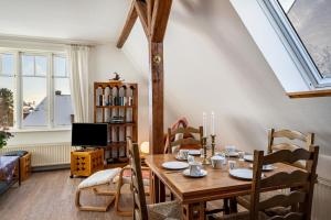 a dining room with a wooden table and a tv at Haus Übersee Wohnung Sansibar in Travemünde