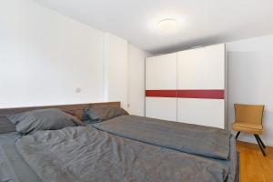 a bedroom with a bed and a chair at Ferienwohnung Merlin in Ettenheim
