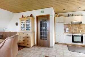 a kitchen with white cabinets and a wooden ceiling at Ferienwohnung Haus Barbara in Bräunlingen