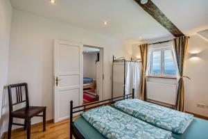 a bedroom with a bed and a chair and a window at Ferienhaus S' Äckerle in Lauf
