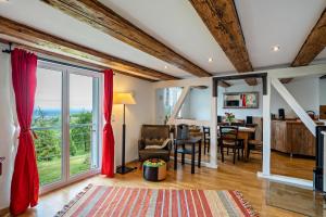 a living room with red curtains and a dining room at Ferienhaus S' Äckerle in Lauf