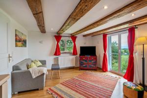 a living room with red curtains and a television at Ferienhaus S' Äckerle in Lauf