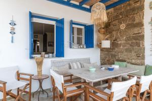 a dining room with a wooden table and chairs at Waterfront Masterpiece in Tinos