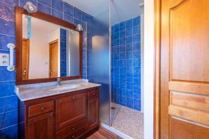 a blue tiled bathroom with a sink and a shower at Maison avec piscine in Marciac +21 photos