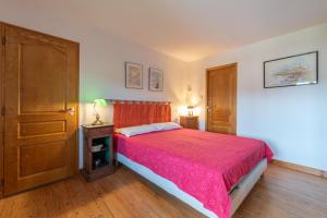 a bedroom with a bed with a red bedspread at Maison avec piscine in Marciac