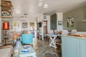 a kitchen and living room with a table and chairs at Waterfront Masterpiece in Tinos +26 photos
