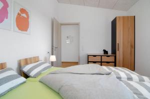 two beds in a bedroom with white walls at Ferienwohnungen Walz in Pfullendorf