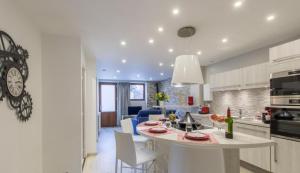 a kitchen and living room with a table and chairs at Le Clos Savoie Lorraine in Thônes