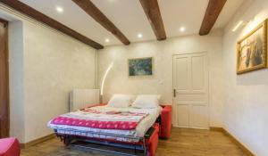 a bedroom with a bed with a red ottoman at Le Clos Savoie Lorraine in Thônes