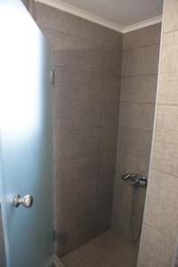 a bathroom with a shower with a glass door at Tigani House in Tyros +42 photos