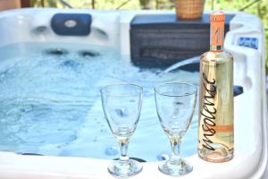 a bottle of wine and two glasses in a tub at Doliva Studio John private jacuzzi in Agios Gordios