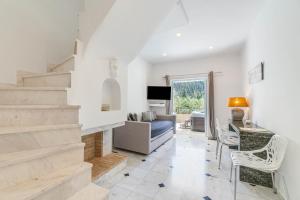a living room with a staircase and a couch at Doliva Studio John private jacuzzi in Agios Gordios