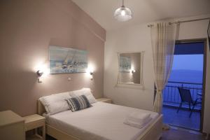 a bedroom with a bed with a view of the ocean at Tigani House in Tyros