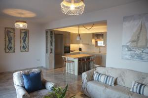 a living room with a couch and a kitchen at Tigani House in Tyros