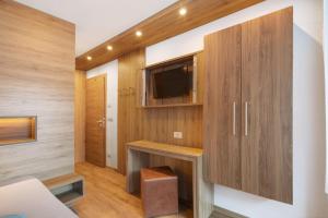a living room with a tv and wooden walls at Pension Waldheim Apartments in San Giacomo