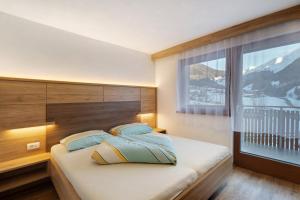 a bedroom with a bed with a large window at Pension Waldheim Apartments in San Giacomo