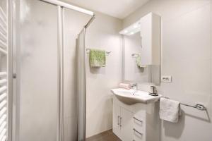 a white bathroom with a sink and a shower at Pension Waldheim Apartments in San Giacomo +54 photos