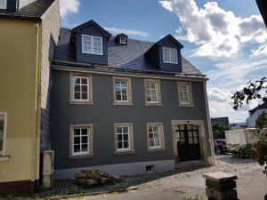 a gray house with a black roof at Rosenzauber-Seeromantik in Weißenstadt