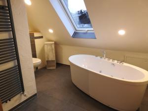 a bathroom with a large bath tub and a window at Rosenzauber-Seeromantik in Weißenstadt