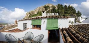a white house with green shutters on a roof at La Casa del Risco Zahara in Zahara de la Sierra
