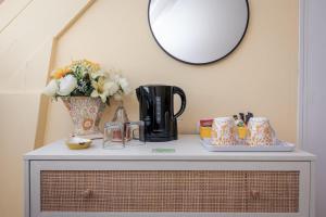 a table with a vase and a mirror on it at Le Verger Chambres d'hotes in Ségur-le-Château +31 photos