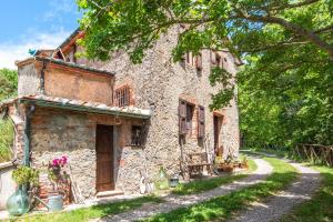 an old stone house with a pathway in front of it at Paradis Oasis Santa Maria in Chiusdino