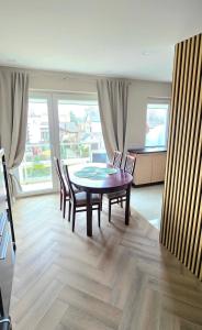 a dining room with a wooden table and chairs at Justinos Vila in Palanga