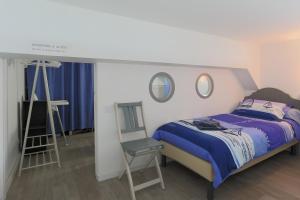 a bedroom with a bed and a ladder and two mirrors at Ti Roz - Vue mer in Perros-Guirec