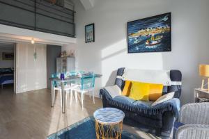 a living room with a couch and a table at Ti Roz - Vue mer in Perros-Guirec +26 photos