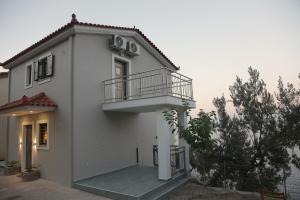 a white house with a balcony on the side at Tigani House in Tyros