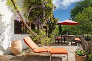 a patio with chairs and a table with an umbrella at Ferienhaus Auszeithaus in Zell
