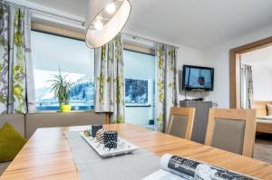 a dining room with a table and a large window at Haus Sabrina Kreuzjoch in See