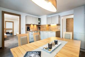 a kitchen and dining room with a wooden table at Haus Sabrina Kreuzjoch in See