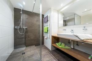 a bathroom with a shower and a sink and a mirror at Haus Sabrina Kreuzjoch in See +9 photos