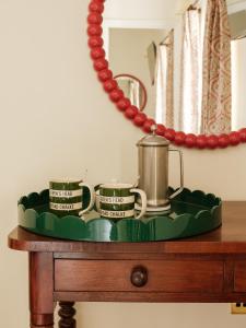 a tray with three cups and a tea kettle on a table at The Queen's Head in Broad Chalke