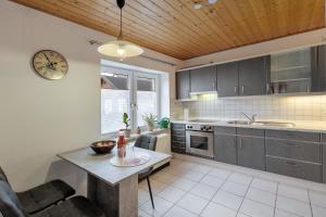 a kitchen with a table and a clock on the wall at Naturoase Fichtelberg in Fichtelberg