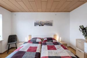a bedroom with a bed with a striped blanket at Naturoase Fichtelberg in Fichtelberg