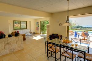 a kitchen and living room with a table and chairs at Villa Ippokampos Ideales Resort in Kefallonia