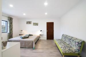 a bedroom with a bed and a couch at Apartamento nº3 - Familiar in Moncarapacho