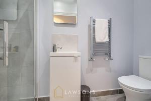 a white bathroom with a toilet and a sink at Fit for a King-size Nap I Parking in Windsor