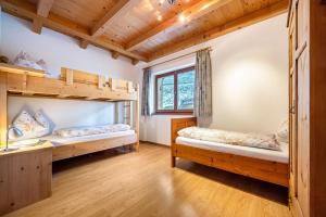 two bunk beds in a room with wooden ceilings at Raffreiderhof Apt Fichte in Luson