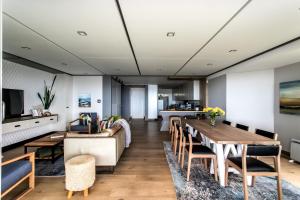 a living room with a table and chairs at Bayview 203 in Hermanus +11 photos