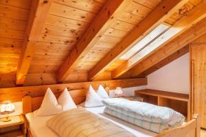 a bed in a room with a wooden ceiling at Ferienwohnung Kramer in Grainau