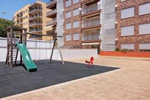 a child playing on a swing set in a playground at Apartamento Armação de Pêra in Armação de Pêra