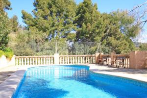 a swimming pool in a backyard with a wooden fence at Montemar 34 in Port de Soller