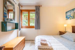 a bedroom with a bed and a tv and a window at Montemar 34 in Port de Soller +18 photos