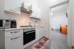 a kitchen with white cabinets and a black oven at Casa Andrea in Assemini