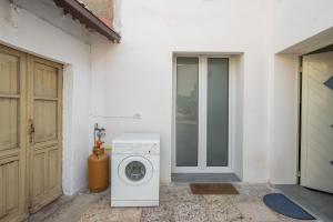 a washing machine sitting outside of a house with a door at Casa Andrea in Assemini