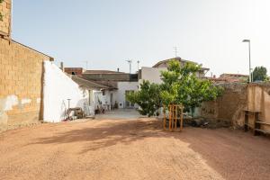 a dirt road with a tree in a village at Casa Andrea in Assemini